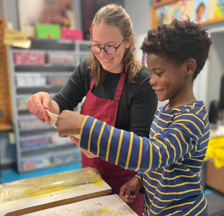 One of our teachers printing with a smiling Benton student.