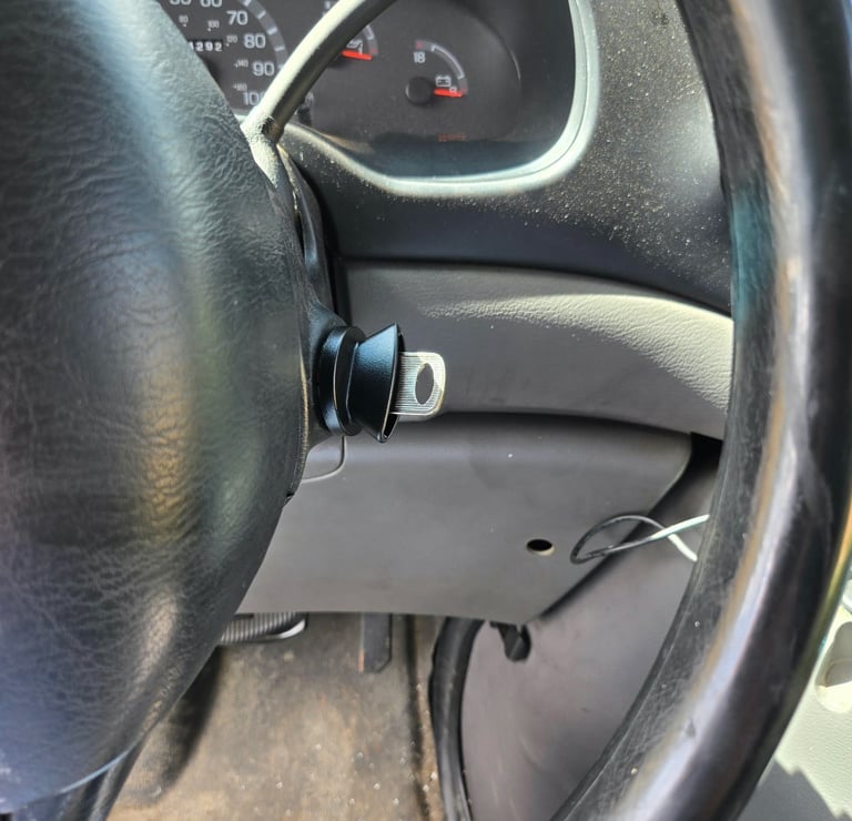 Car key I replacement inserted in the ignition near the steering wheel