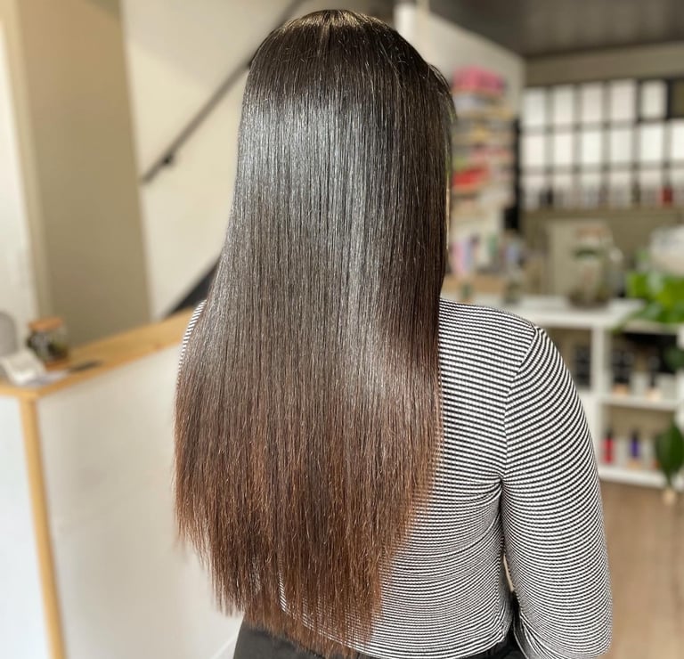 une femme aux cheveux longs après l'avoir lissés et une chemise à rayures