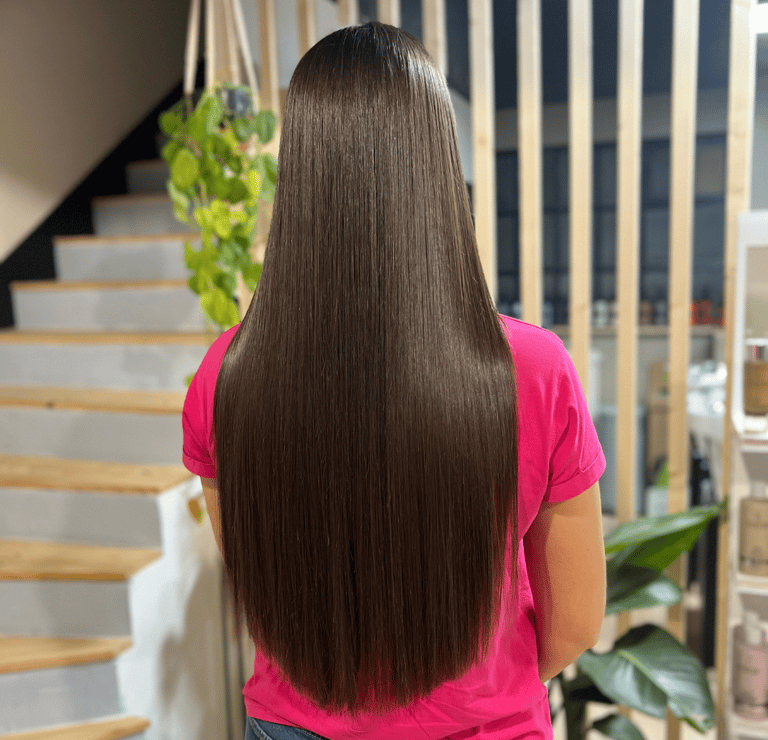 une femme assise sur une chaise avec ses cheveux après s'être lissé les cheveux sur une chaise