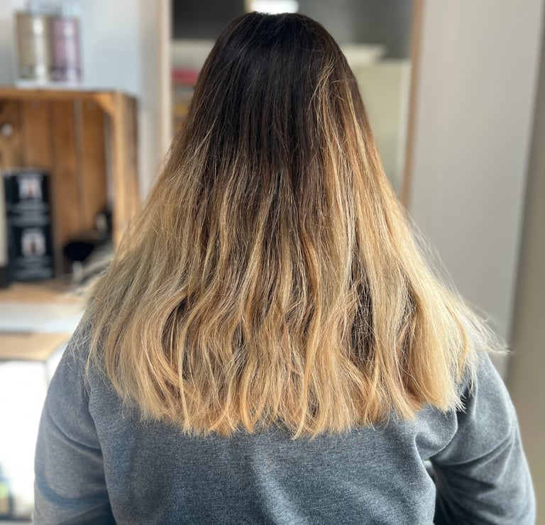 une femme aux cheveux blonds et au pull gris