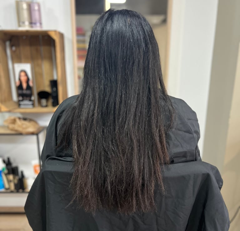 une femme aux cheveux longs avant l'avoir lissés et une chemise à rayures