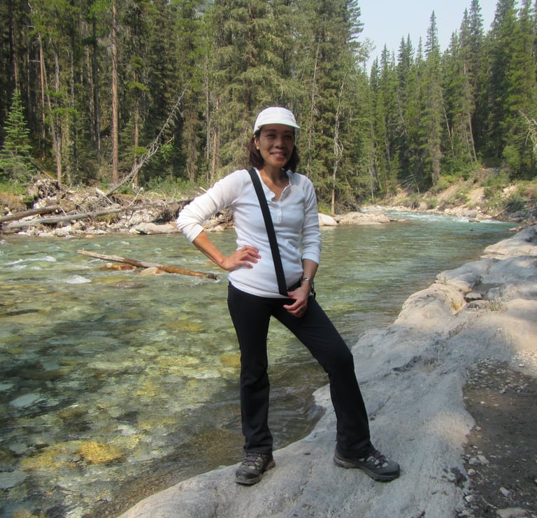 a person standing on a rock by the cascade river