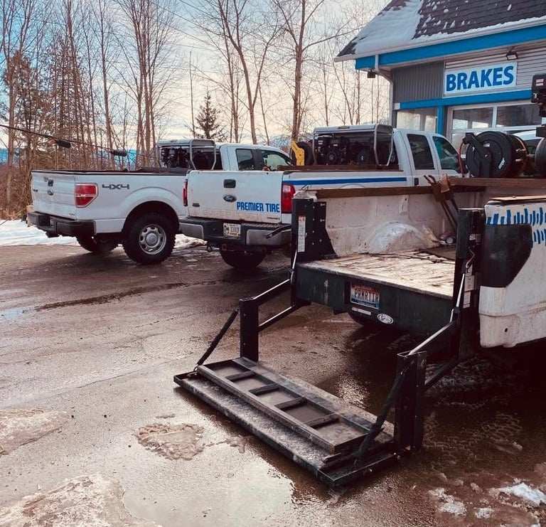 Service trucks parked outside a Premier Tire and brake repair shop in winter.