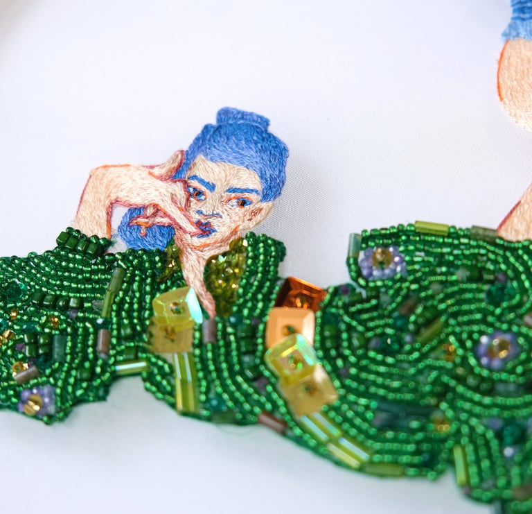 details of an embroidery on organza of a woman in a green dress made with beads