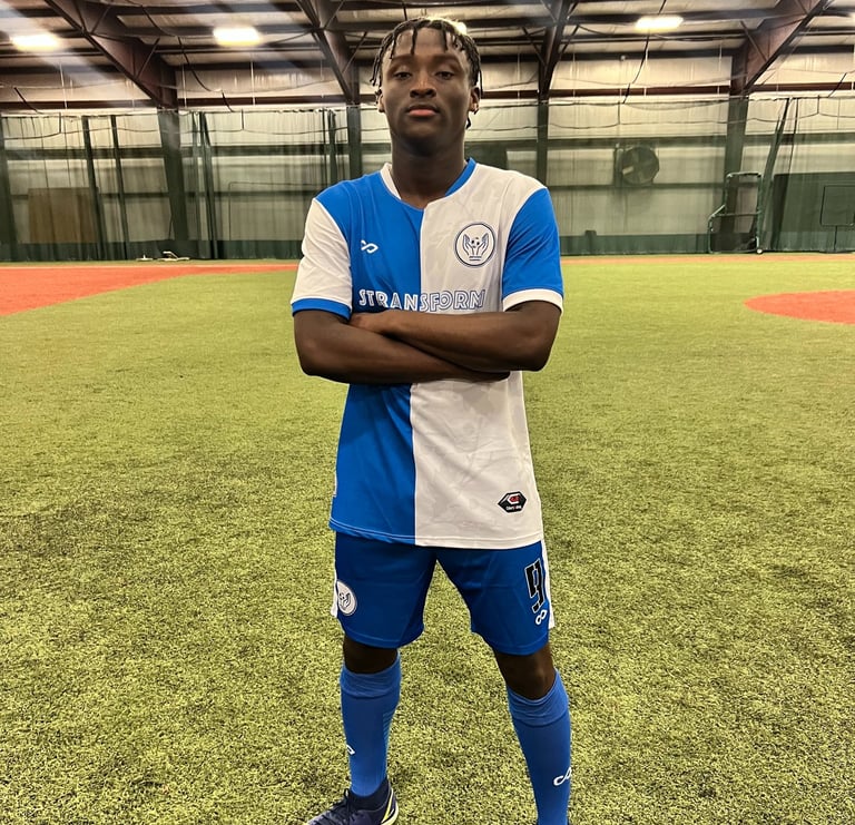 a man in a blue and white soccer uniform standing in a soccer field