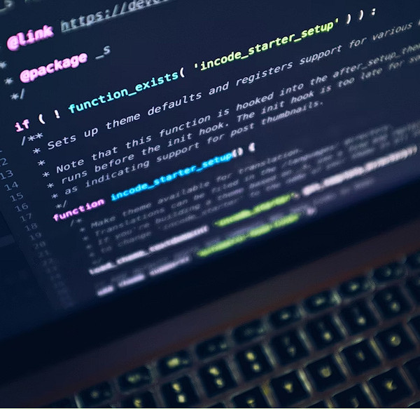 Close-up of PHP backend code and syntax highlighting on a laptop screen.