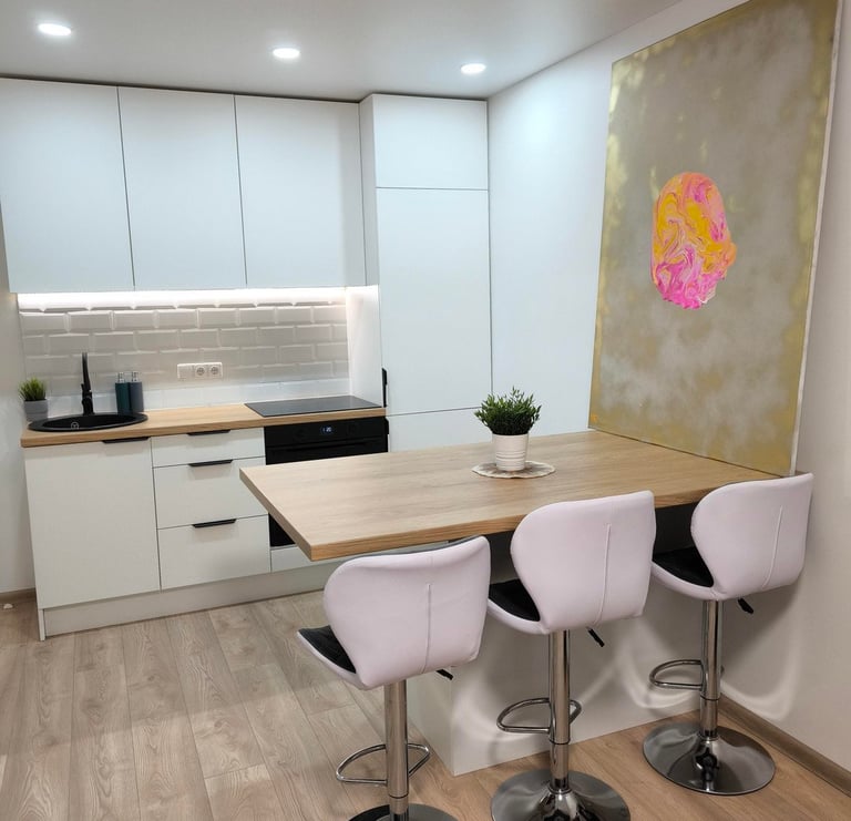 a kitchen with a table and chairs and a painting