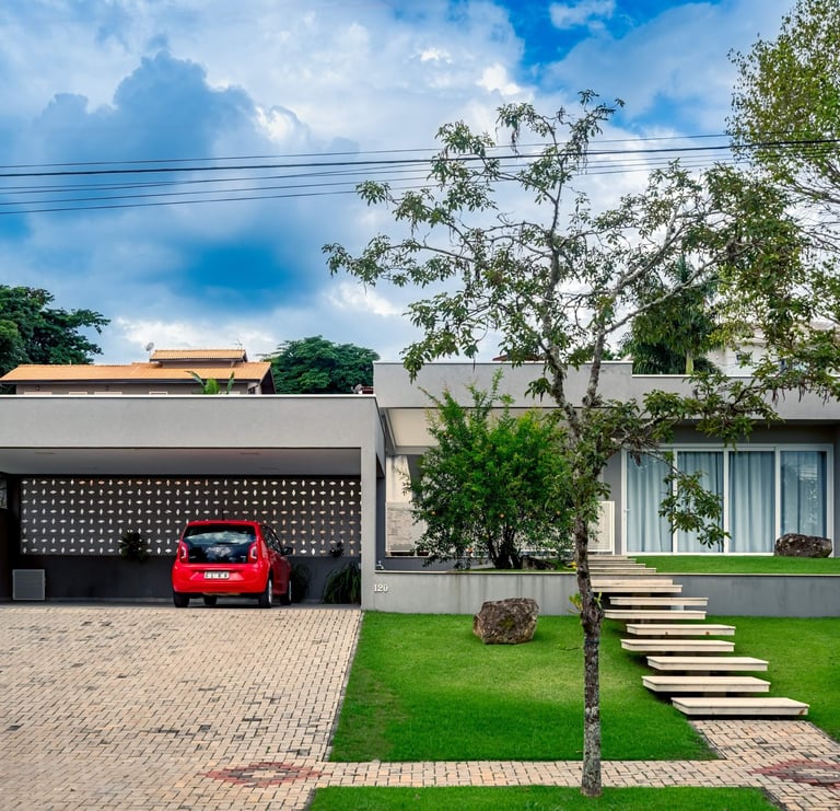 fachada cinza de casa contemporânea e carro vermelho