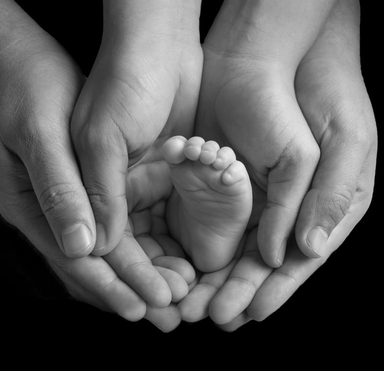 los papás de un bebé sosteniéndolo con sus manos