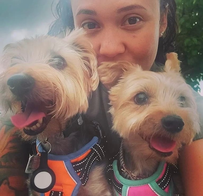 a woman holding two dogs in her arms