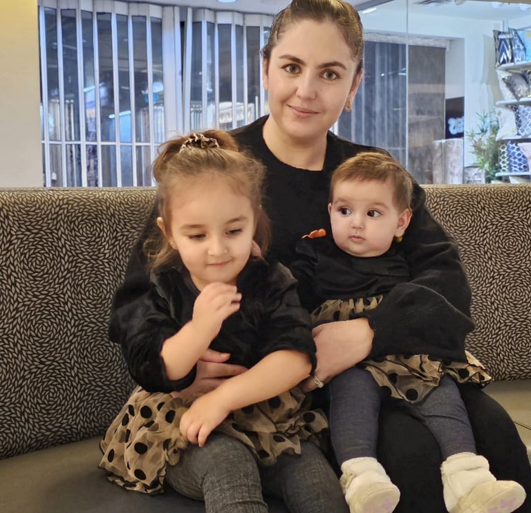a woman sitting on a couch with two children