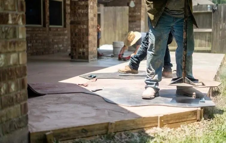 men working on a concrete patio
