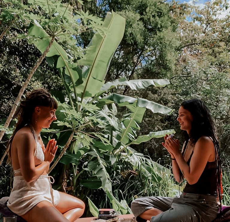 two women sitting on a deck with a cup of tea doing oracle tarot reading