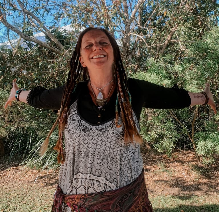 a woman with dreadlocks and dreadlocks standing in front of a tree