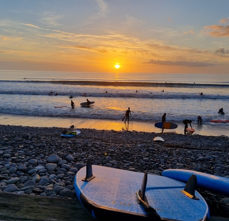 Beautiful sunset at Ynyslas with surfboard fins and busy surf lesson