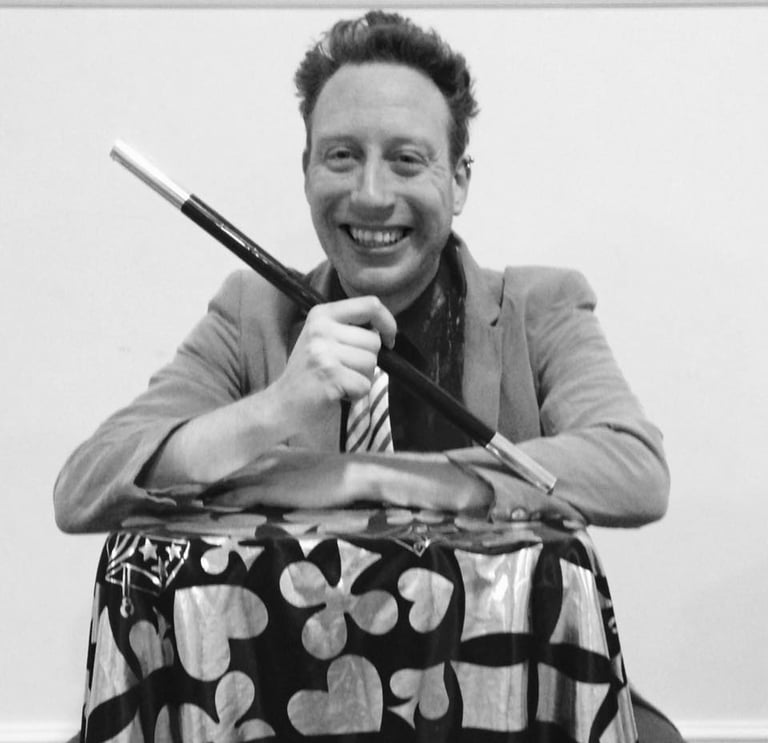 a man in a suit and tie is smiling and holding a knife and knife