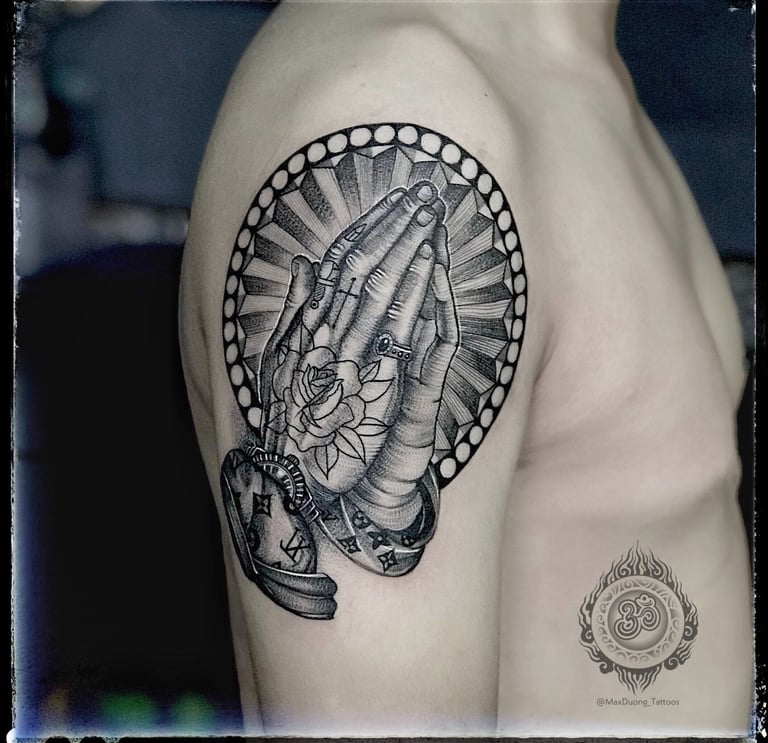 Blackwork tattoo of a praying hand with a rose tattoo on the upper arm