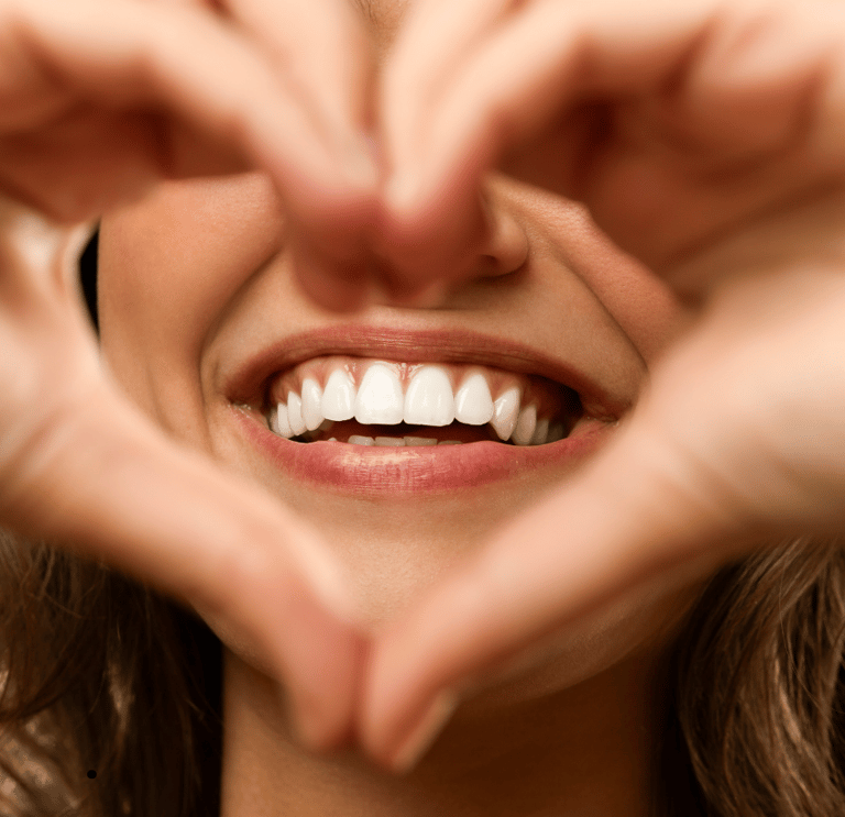 Person smiling confidently after a comprehensive smile makeover, featuring perfectly aligned and bri