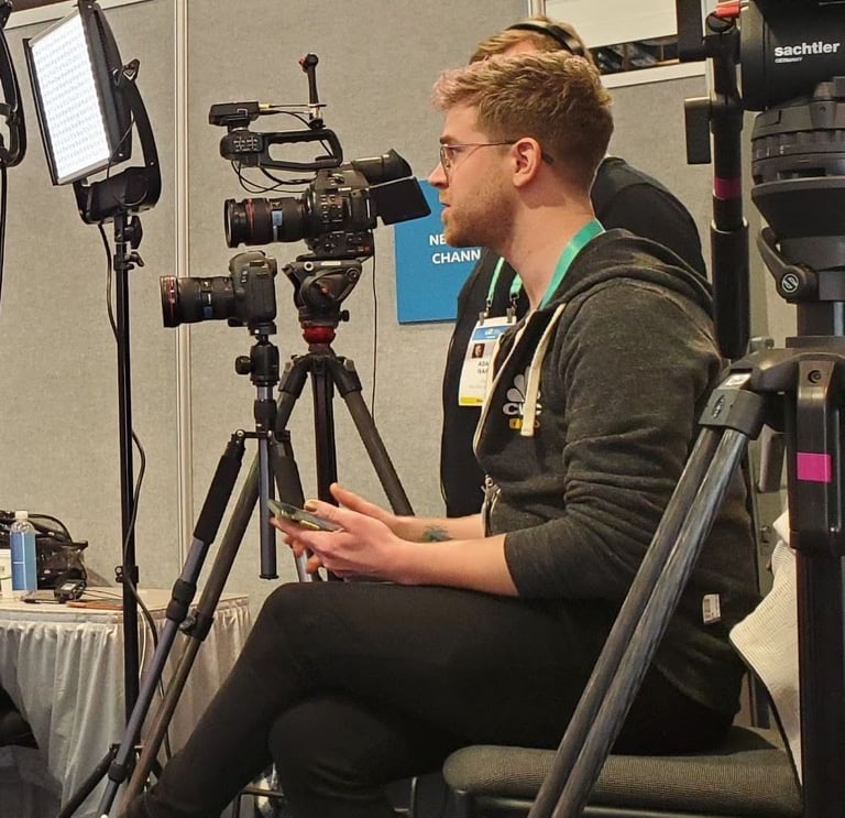 Dain Evans in a black jacket with a camera