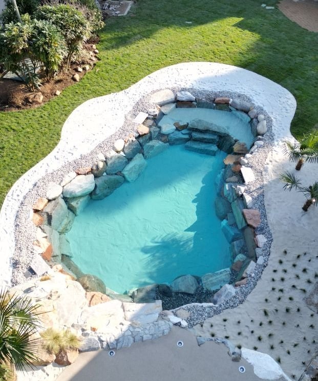 piscina naturale con sabbia bianca palme e rocce 
