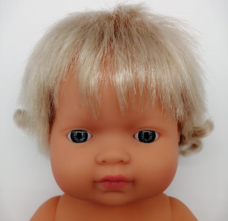 a Miniland baby doll with blonde hair and blue eyes