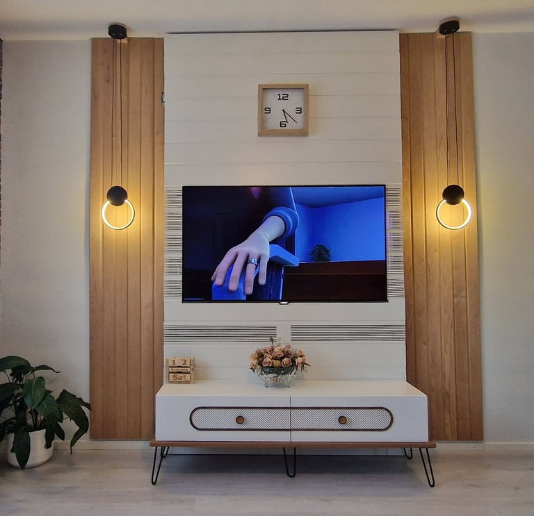 Modern living room TV wall unit with wood panels, circular LED lights, and white TV stand.