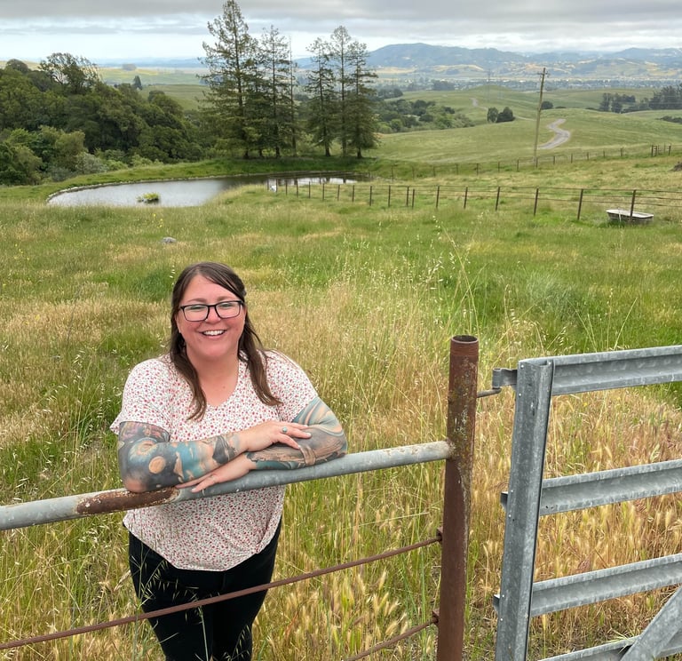 a woman standing in front of a fenced in area