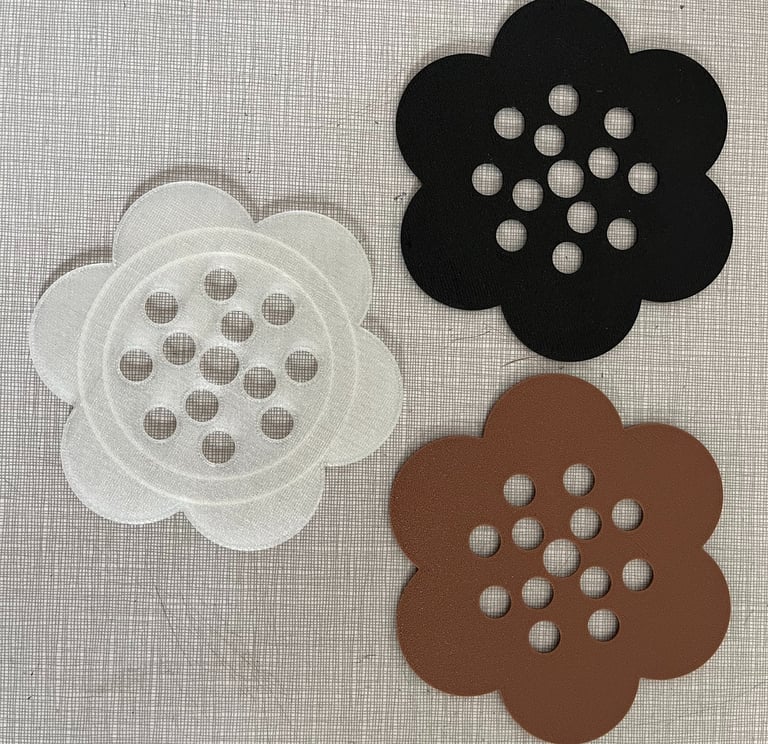 three plastic flower frogs in black, brown, and clear