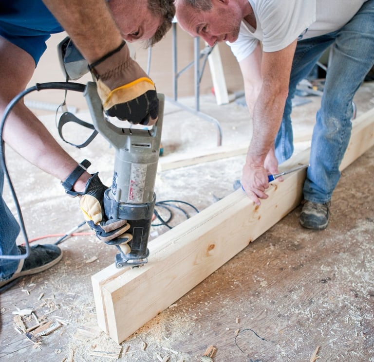two men cutting a piece of wood