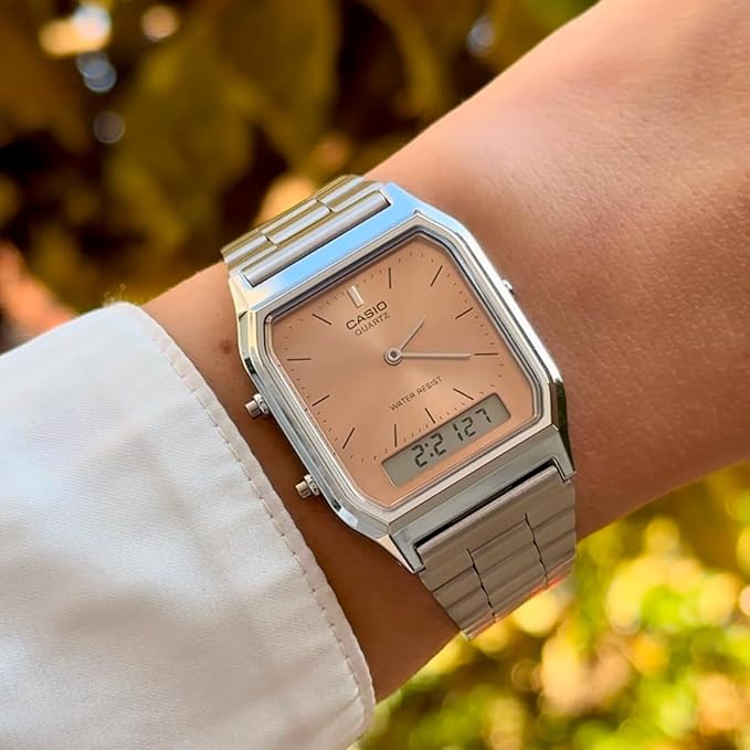 Silver Casio vintage watch with a salmon pink dial and ana-digi display on a wrist.