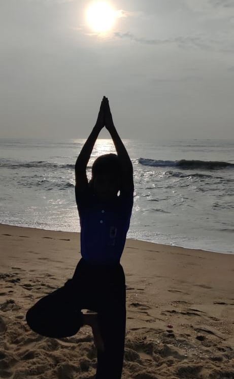 a person doing yoga on a beach