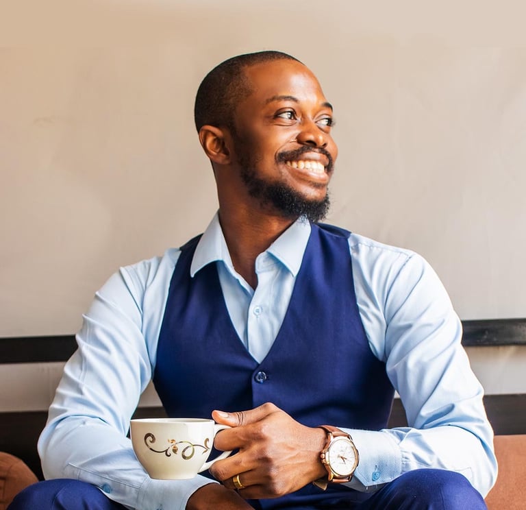 a man wearing a blue semi-formal attire holding a cup of tea