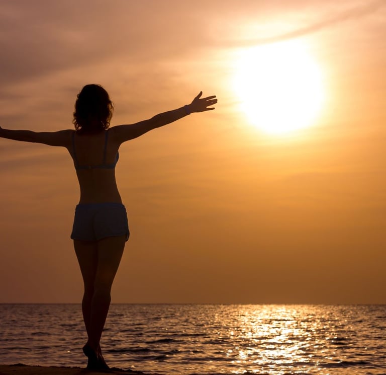 femme libre et heureuse qui regarde l'horizon en levant les bras