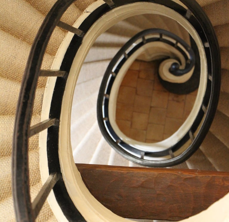 a spiral staircase with a wooden staircase case