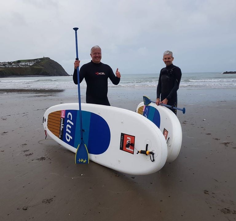 Derek 'The Weatherman' Brockway wituh paddle boards on Borth Beach.