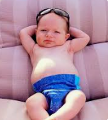 a baby wearing a blue swim suit and sunglasses