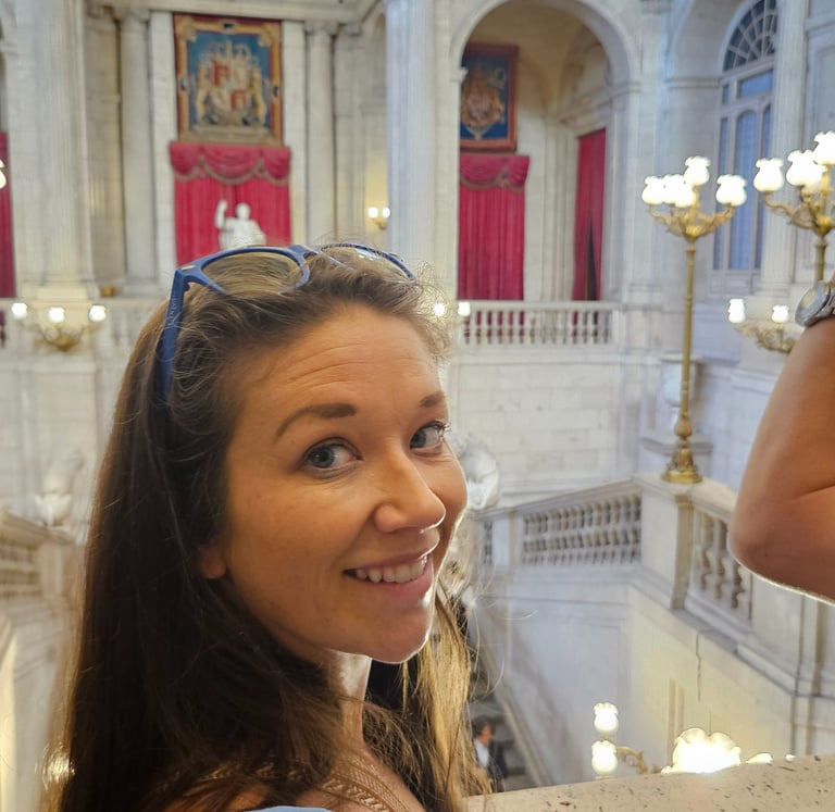 Mom covers shoulders in Spain while visiting historical sites, ensuring proper packing & planning