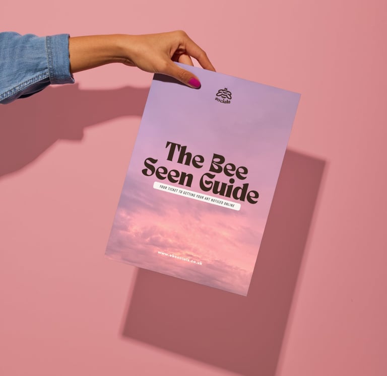 A hand holding a copy of 'the bee seen guide' on a pink background