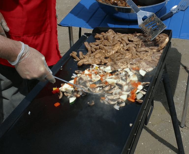 a person is cooking food on a grill