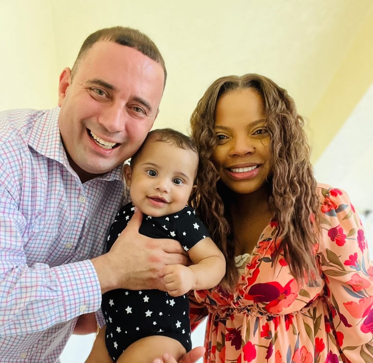 a man and woman holding a baby in a room