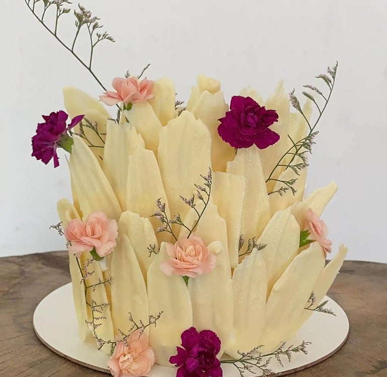Bolo decorado com detalhes florais e texturas que imitam pétalas, ideal para festas e celebrações. D