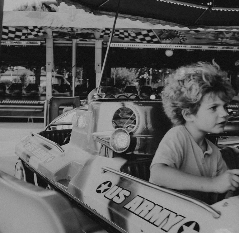a young boy riding on a bumper car