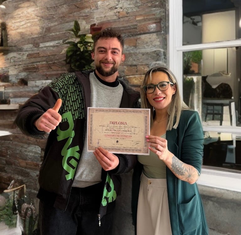 Alumno junto a Rebeca Pereira durante la entrega de diploma tras completar su formación de tatuaje
