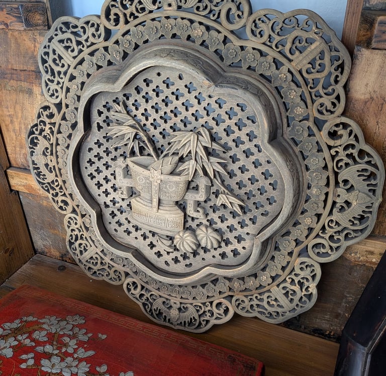 Ornate Chinese wood wall plaque featuring intricate floral and bamboo patterns.