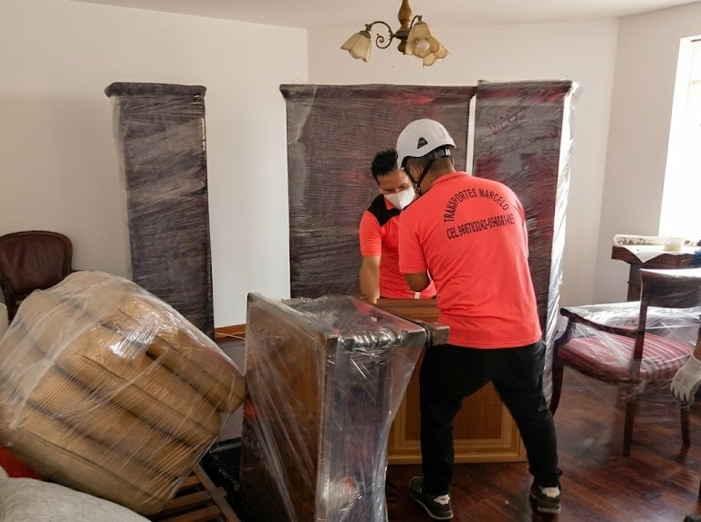 Operarios de Mudanzas Marcelo realizando el traslado delicado de muebles con embalaje de alta densid
