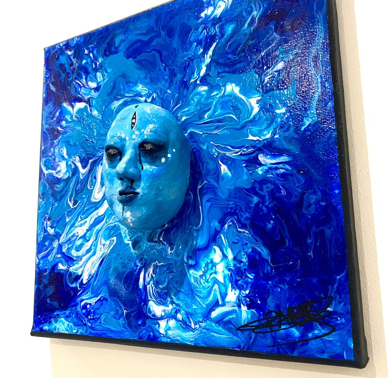 une sculpture bleue qui émerge d'un tableau bleu vu de côtés