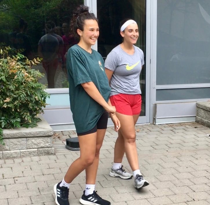 Two women after Jeet Kune Do North York training in a courtyard area.