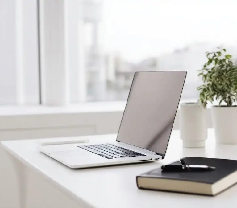Moderner Arbeitsplatz mit Laptop und Notizbuch