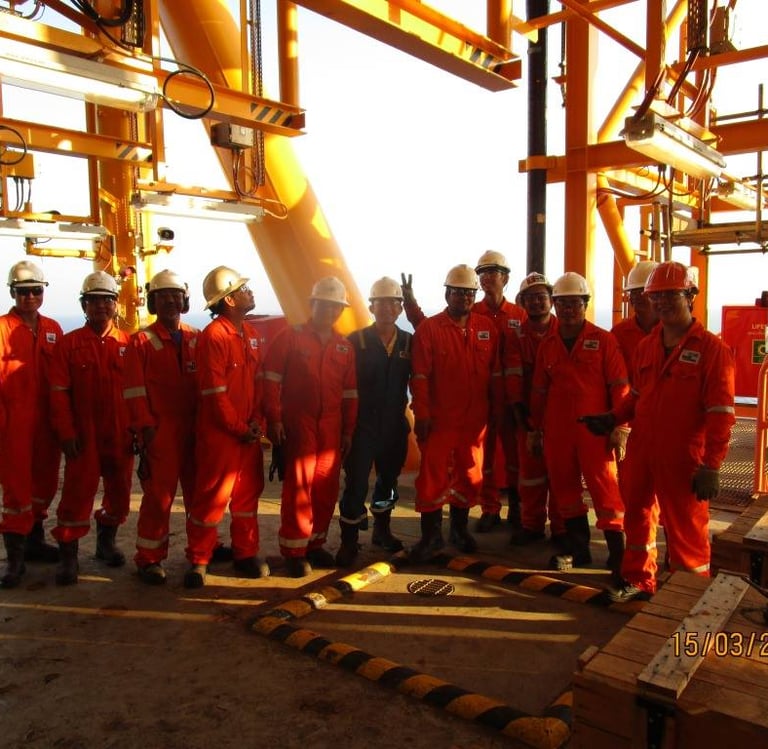Offshore oil rig workers hard hats posing on a platform.
